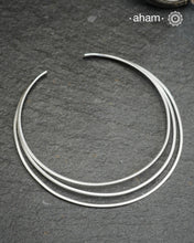 Discover understated luxury with this three-line silver hasli, a masterfully crafted collar piece in 92.5 sterling silver. Its clean, geometric design bridges the gap between casual and formal wear—pair it effortlessly with your favourite shirt or dress. The versatile open framework welcomes customization; add a pendant to create a signature look or wear it bare for refined minimalism. Handcrafted with precision, this piece embodies timeless elegance and adaptability for the discerning jewellery enthusiast.