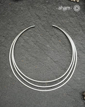 Discover understated luxury with this three-line silver hasli, a masterfully crafted collar piece in 92.5 sterling silver. Its clean, geometric design bridges the gap between casual and formal wear—pair it effortlessly with your favourite shirt or dress. The versatile open framework welcomes customization; add a pendant to create a signature look or wear it bare for refined minimalism. Handcrafted with precision, this piece embodies timeless elegance and adaptability for the discerning jewellery enthusiast.