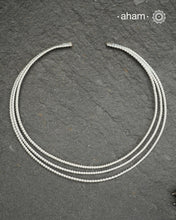Discover understated elegance with this three-line twisted silver hasli, a masterfully crafted collar piece in 92.5 sterling silver. Its clean, geometric design bridges the gap between casual and formal wear—pair it effortlessly with your favourite shirt or dress. The versatile open framework welcomes customization; add a pendant to create a signature look or wear it bare for refined minimalism. Handcrafted with precision, this is a timeless piece you would love to wear.