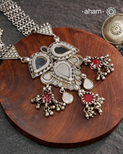 This Mewad White Glass Silver Neckpiece showcases a beautifully crafted glass pendant made by skilled karigars in Barmer, accented with vintage red glass drops. Complemented by elegant silver side bands, it reflects exquisite craftsmanship and adds a graceful, timeless charm to your jewelry collection.