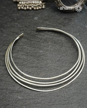Discover understated luxury with this four-line silver hasli, a masterfully crafted collar piece in 92.5 sterling silver. Its clean, geometric design bridges the gap between casual and formal wear—pair it effortlessly with your favourite shirt or dress. The versatile open framework welcomes customization; add a pendant to create a signature look or wear it bare for refined minimalism. Handcrafted with precision, this piece embodies timeless elegance and adaptability for the discerning jewellery