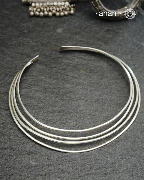 Discover understated luxury with this four-line silver hasli, a masterfully crafted collar piece in 92.5 sterling silver. Its clean, geometric design bridges the gap between casual and formal wear—pair it effortlessly with your favourite shirt or dress. The versatile open framework welcomes customization; add a pendant to create a signature look or wear it bare for refined minimalism. Handcrafted with precision, this piece embodies timeless elegance and adaptability for the discerning jewellery