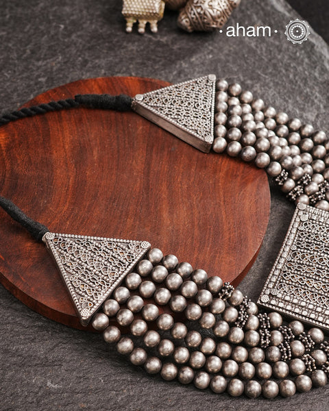 This expert-crafted Mewad Silver Neckpiece features a striking central pendant flanked by side triangles, all detailed with fine tar work. Its bold design makes it an exceptional statement piece, perfect for elevating any outfit with a touch of traditional artistry and refined craftsmanship. 