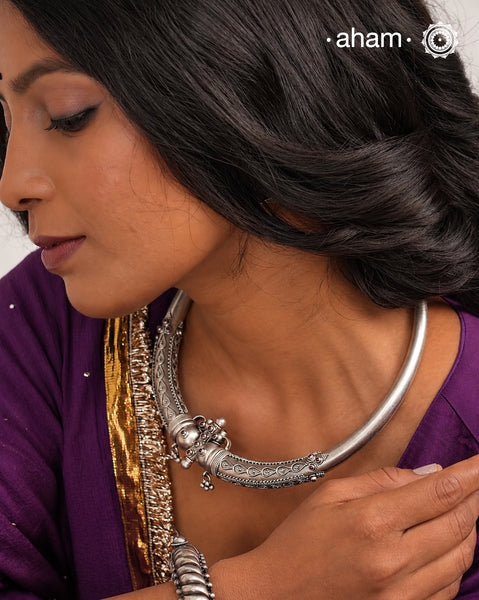 Mewad Silver Hasli crafted in 92.5 sterling silver, featuring exquisite rava and tar work that showcases traditional artisanal techniques. This reversible piece displays identical intricate detailing on both sides, allowing you to wear it according to your preference. The meticulous handwork reflects the heritage of Mewad craftsmanship, making it a versatile addition to your jewellery collection that transitions seamlessly between occasions.
