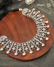 Graceful and intricately detailed, this handcrafted silver neckpiece crafted in 92.5 silver is designed to make a statement through its beautifully balanced composition. Delicate openwork, sculpted floral accents, and polished silver drops come together in a rhythmic pattern that lends the piece depth, texture, and movement.

Despite its striking appearance, the neckpiece is lightweight and comfortable to wear, making it an effortless choice for both everyday dressing and special occasions. 