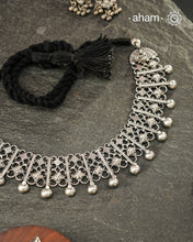 Graceful and intricately detailed, this handcrafted silver neckpiece crafted in 92.5 silver is designed to make a statement through its beautifully balanced composition. Delicate openwork, sculpted floral accents, and polished silver drops come together in a rhythmic pattern that lends the piece depth, texture, and movement.

Despite its striking appearance, the neckpiece is lightweight and comfortable to wear, making it an effortless choice for both everyday dressing and special occasions. 