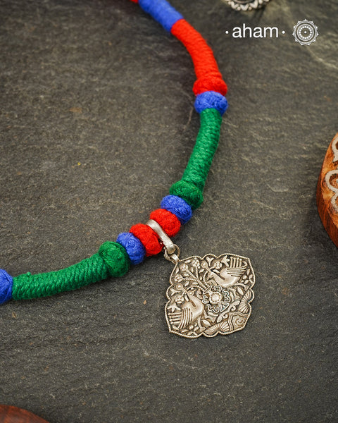 Show off your unique style with the Mewad Silver Neckpiece. A light weight pendant at the center with coloured thread, this neckpiece is sure to add a pop of colour to any outfit. Elevate your look and stand out from the crowd with this beautiful neckpiece.