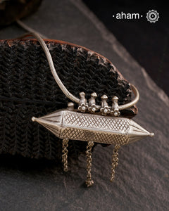 This Vintage Amulet Silver Neckpiece showcases authentic tribal craftsmanship from South India, reflecting rich cultural heritage. Handcrafted in sterling silver, it features intricate detailing that embodies traditional design elements. Perfect for collectors and connoisseurs, this piece adds a unique, timeless accent to any ensemble while honoring artisanal legacy.