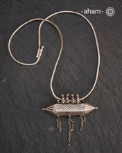 This Vintage Amulet Silver Neckpiece showcases authentic tribal craftsmanship from South India, reflecting rich cultural heritage. Handcrafted in sterling silver, it features intricate detailing that embodies traditional design elements. Perfect for collectors and connoisseurs, this piece adds a unique, timeless accent to any ensemble while honoring artisanal legacy.