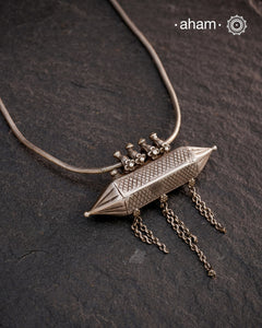 This Vintage Amulet Silver Neckpiece showcases authentic tribal craftsmanship from South India, reflecting rich cultural heritage. Handcrafted in sterling silver, it features intricate detailing that embodies traditional design elements. Perfect for collectors and connoisseurs, this piece adds a unique, timeless accent to any ensemble while honoring artisanal legacy.