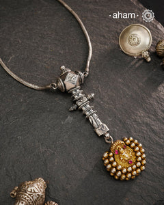 This Krishna Tribal Silver Neckpiece is a unique creation combining a vintage belt buckle and a vintage Krishna hair pin into a distinctive pendant. Expertly crafted in silver and finished with a woven chain, it offers a rare blend of heritage elements and artisanal craftsmanship, making it a remarkable statement piece for collectors and connoisseurs of fine jewellery.