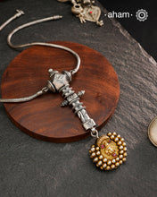 This Krishna Tribal Silver Neckpiece is a unique creation combining a vintage belt buckle and a vintage Krishna hair pin into a distinctive pendant. Expertly crafted in silver and finished with a woven chain, it offers a rare blend of heritage elements and artisanal craftsmanship, making it a remarkable statement piece for collectors and connoisseurs of fine jewellery.