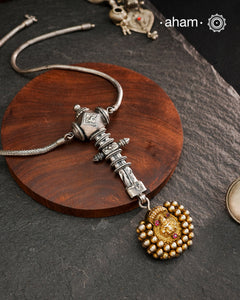 This Krishna Tribal Silver Neckpiece is a unique creation combining a vintage belt buckle and a vintage Krishna hair pin into a distinctive pendant. Expertly crafted in silver and finished with a woven chain, it offers a rare blend of heritage elements and artisanal craftsmanship, making it a remarkable statement piece for collectors and connoisseurs of fine jewellery.