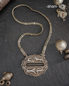 This Lion &amp; Deer Vintage Silver Neckpiece combines two rare vintage elements from different regions of India. The pendant, originally a belt buckle from Rajasthan, features a jungle hunting scene with a lion or tiger chasing a deer. Paired with a vintage belt chain from Karnataka, these distinct pieces merge to form a striking and powerful silver neckpiece. Expertly handcrafted, this neckpiece embodies a powerful narrative and exceptional craftsmanship, making it a rare and meaningful addition to 