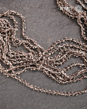 The Odhisa Dhaan Mala Silver Neckpiece is a masterful vintage creation featuring multiple strands of delicately crafted rice-shaped silver beads. Each bead is meticulously formed, reflecting exceptional craftsmanship rooted in Odisha’s rich heritage. This intricate neckpiece offers a timeless elegance, perfect for those who appreciate artisanal detail and cultural artistry in their jewellery collection.