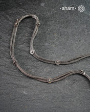 This handcrafted silver neckpiece features a revered Shiva lingam design, rooted in the spiritual traditions of the Lingayat community. The piece showcases meticulous artisanal craftsmanship, with its distinctive projection elegantly referencing Nandi, the sacred bull. Historically significant among Shaivite practitioners, particularly from Karnataka, this vintage-inspired silver casket serves as both a devotional ornament and cultural emblem. 