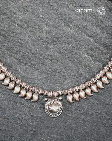 Rooted in the living traditions of Odisha’s tribe, this rare Odhia neckpiece is a celebration of tribal artistry preserved through generations. Crafted in authentic silver and traditionally strung on cotton thread, each bead is meticulously hand-worked using age-old techniques passed down by master artisans.

See the detailing of every element. The beautiful ambi shaped beads in two different sizes and the intricately details beads, all crafted in high grade silve.&nbsp; &nbsp;Every element of the neckpiece