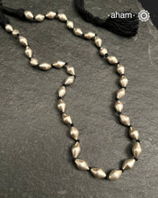 Silver Dholki/ Wax Beads coated with silver foil with black adjustable thread. Also known as Bor Mala