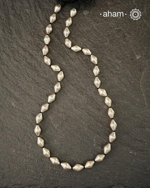 Silver Dholki/ Wax Beads coated with silver foil with black adjustable thread. Also known as Bor Mala