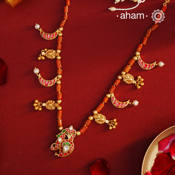 Experience timeless elegance with our Gold Polish Silver Neckpiece. Crafted with raw coral beads and intricate kundan tukdis, this short neckpiece exudes subtle charm. Its traditional design crafted in silver and shining gold polish make it a beautiful addition to any jewellery lovers collection. Indulge in eternal style with our everygreen neckpiece.
