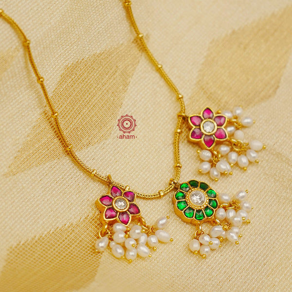 This exquisite silver necklace is handcrafted with gorgeous green and pink kundan work and white pearls for an elegant finish. Its lightweight design makes it perfect for family events and festivities.