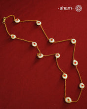 This handcrafted silver neckpiece features exquisite mother of pearl and intricate kundan inlay work, enhanced with a refined gold polish. Designed for versatility, it can be worn as a single long line or doubled for a layered look, making it a sophisticated addition to any jewellery collection.