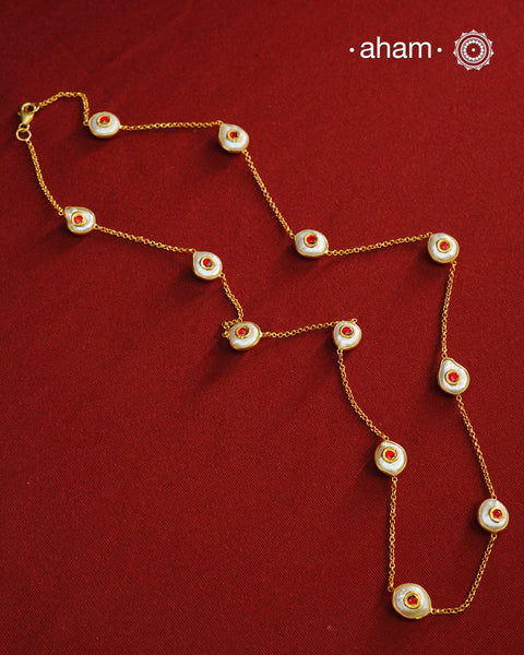 This handcrafted silver neckpiece features exquisite mother of pearl and intricate kundan inlay work, enhanced with a refined gold polish. Designed for versatility, it can be worn as a single long line or doubled for a layered look, making it a sophisticated addition to any jewellery collection.