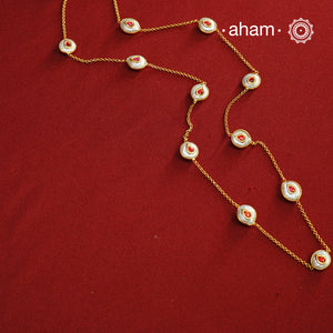 This handcrafted silver neckpiece features exquisite mother of pearl and intricate kundan inlay work, enhanced with a refined gold polish. Designed for versatility, it can be worn as a single long line or doubled for a layered look, making it a sophisticated addition to any jewellery collection.