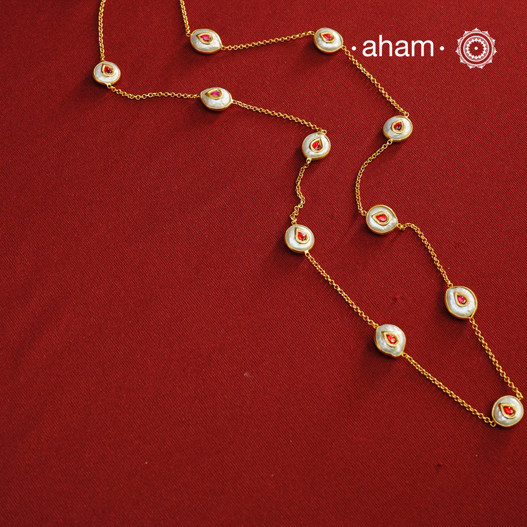 This handcrafted silver neckpiece features exquisite mother of pearl and intricate kundan inlay work, enhanced with a refined gold polish. Designed for versatility, it can be worn as a single long line or doubled for a layered look, making it a sophisticated addition to any jewellery collection.