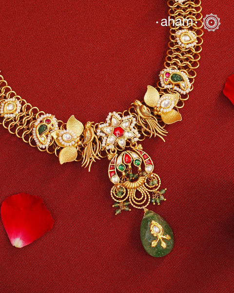This hand made neckpiece is a modern twist on traditional designs. Crafted with 92.5 silver and adorned with stunning kundan work, its gold polish adds a touch of elegance. The beautiful green drop completes the look, showcasing expert traditional craftsmanship.