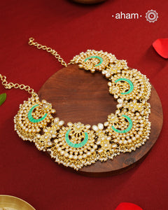 Elevate your festive look with this exquisite Pearl &amp; Turquoise Gold Polish Silver Neckpiece. Crafted in 92.5% silver with a delicate gold polish, its chand-shaped design beautifully blends vibrant turquoise and lustrous pearls. Ideal for mehandi, haldi ceremonies, or a friend’s wedding, this piece adds a touch of elegance and tradition to your ensemble. Make every celebration memorable with this stunning accessory.