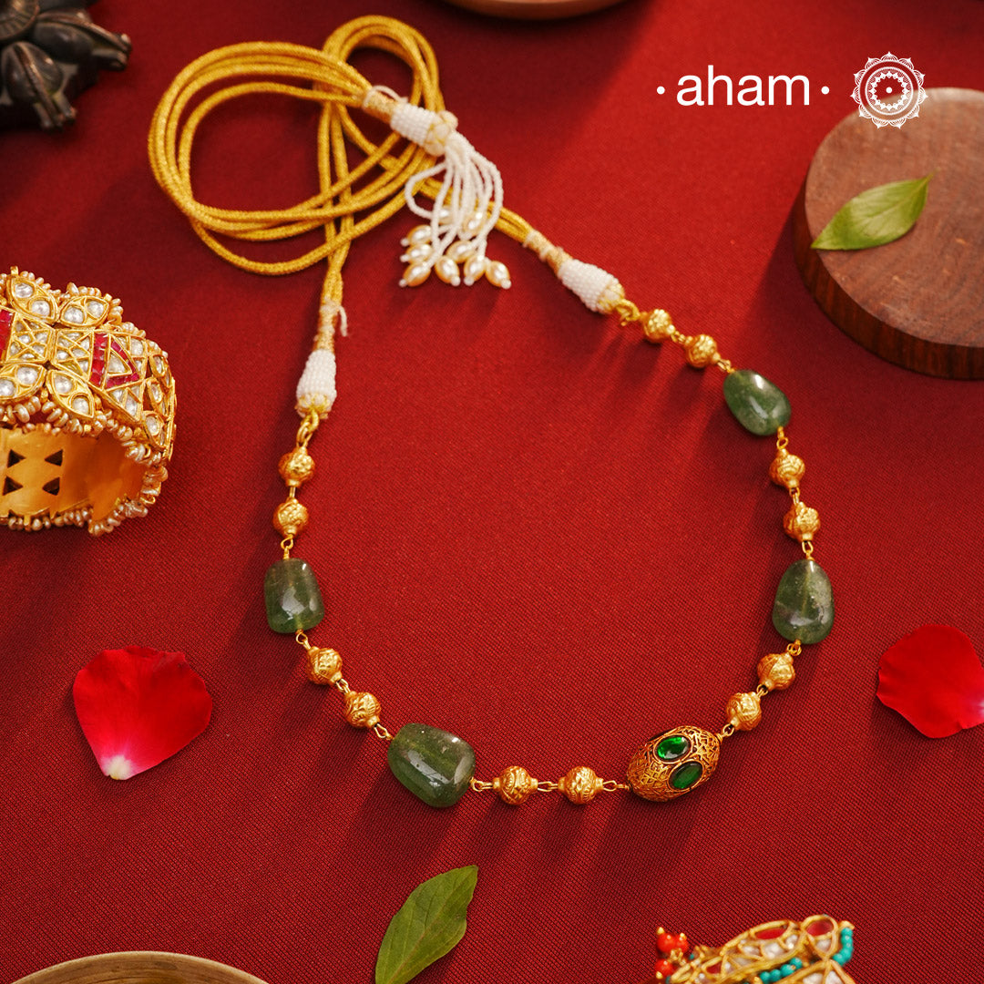 Crafted in 92.5 silver with a stunning gold polish, this neckpiece is sure to make a statement. The delicate gold beads, accented by vibrant green onyx and a kund bead center, add a touch of elegance. Perfect for any occasion, this simple yet striking piece is a must-have for any jewelry collection.