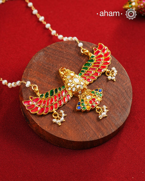 Eagle in flight crafted in 92.5 silver with kundan work and gold polish. Laced with delicate pearls and a pearl chain.