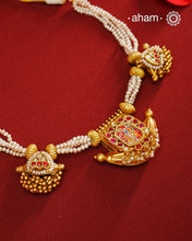 This exquisite neckpiece features 3 silver amulets with a gold polish finish, elegantly strung with lustrous pearls. At its center, the amulet showcases a finely hand-painted miniature depiction of Shrinathji, combining traditional craftsmanship with artistic detail. A distinguished piece that reflects devotion and timeless beauty.