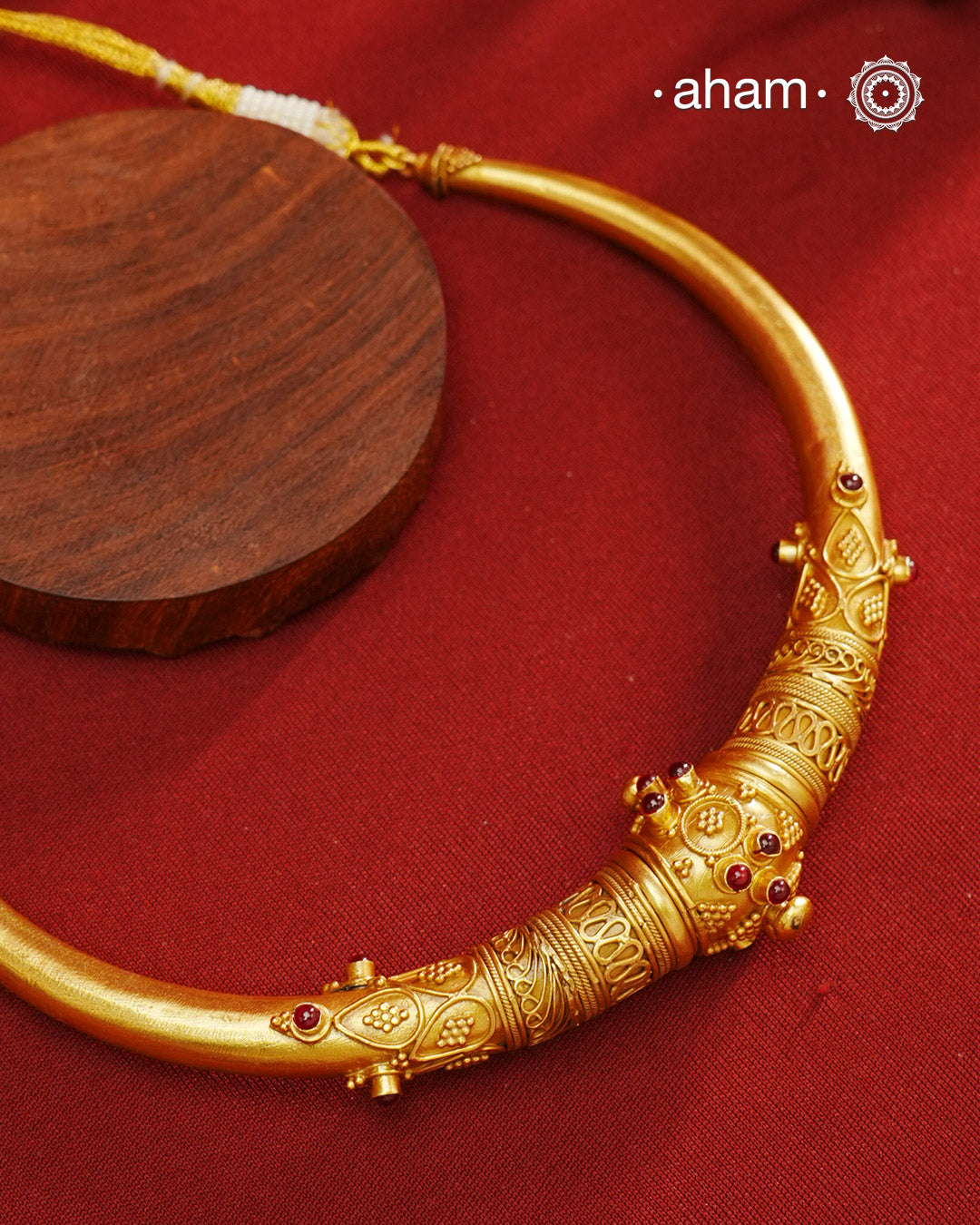 Beautiful gold polish hasli with intricate rawa tar work and maroon kemp highlights. Handcrafted in 92.5 sterling silver with fine gold polish. Comes with adjustable thread for easy of wear. A classic piece that can be cherished across generations.