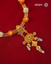 Crafted in 92.5 sterling silver with a radiant 24 carat gold polish, this handcrafted neckpiece brings together traditional craftsmanship and contemporary elegance. The intricately woven chain is accented with vibrant coral-toned beads, delicate freshwater pearl clusters, and an ornate statement pendant featuring intricate hand-finished detailing. Soft faceted natural stone drops add a graceful touch, lending subtle movement and refined charm to the design.