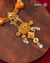Crafted in 92.5 sterling silver with a radiant 24 carat gold polish, this handcrafted neckpiece brings together traditional craftsmanship and contemporary elegance. The intricately woven chain is accented with vibrant coral-toned beads, delicate freshwater pearl clusters, and an ornate statement pendant featuring intricate hand-finished detailing. Soft faceted natural stone drops add a graceful touch, lending subtle movement and refined charm to the design.