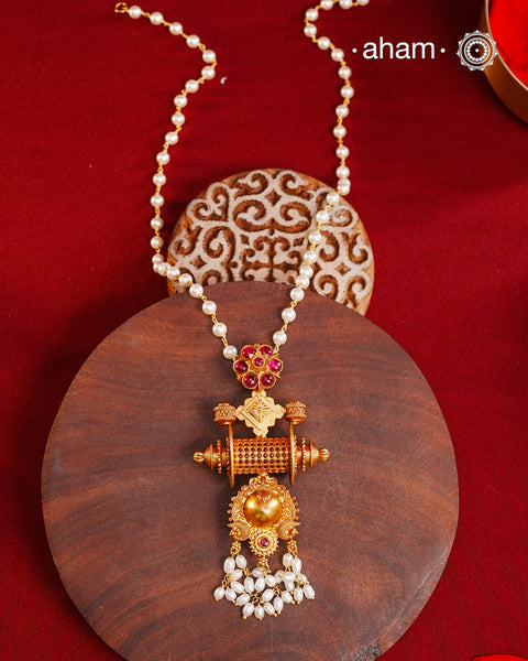 Inspired by the intricate designs of South temple art, this neckpiece is expertly crafted from 92.5% pure silver and finished with a refined dull gold polish. Complemented by a delicate pearl chain, it embodies a harmonious blend of traditional craftsmanship and timeless elegance, ideal for enhancing any special occasion ensemble.
