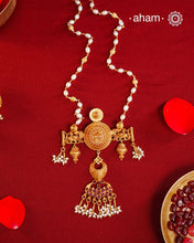 Inspired by the intricate designs of South temple art, this neckpiece is expertly crafted from 92.5% pure silver and finished with a refined dull gold polish. Complemented by a delicate pearl chain, it embodies a harmonious blend of traditional craftsmanship and timeless elegance, ideal for enhancing any special occasion ensemble.