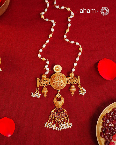 Inspired by the intricate designs of South temple art, this neckpiece is expertly crafted from 92.5% pure silver and finished with a refined dull gold polish. Complemented by a delicate pearl chain, it embodies a harmonious blend of traditional craftsmanship and timeless elegance, ideal for enhancing any special occasion ensemble.