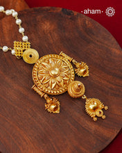 Inspired by the intricate designs of South temple art, this neckpiece is expertly crafted from 92.5% pure silver and finished with fine dull gold polish. Complemented by a delicate pearl chain, it embodies a harmonious blend of traditional craftsmanship and timeless elegance, ideal for enhancing any special occasion ensemble.