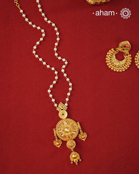 Inspired by the intricate designs of South temple art, this neckpiece is expertly crafted from 92.5% pure silver and finished with fine dull gold polish. Complemented by a delicate pearl chain, it embodies a harmonious blend of traditional craftsmanship and timeless elegance, ideal for enhancing any special occasion ensemble.