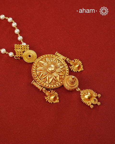 Inspired by the intricate designs of South temple art, this neckpiece is expertly crafted from 92.5% pure silver and finished with fine dull gold polish. Complemented by a delicate pearl chain, it embodies a harmonious blend of traditional craftsmanship and timeless elegance, ideal for enhancing any special occasion ensemble.