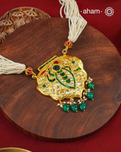 Crafted in 92.5 sterling silver with a radiant 24 carat gold polish, this handcrafted neckpiece draws inspiration from the divine adornments of Shrinathji. The intricately detailed pendant is embellished with traditional kundan work, vibrant emerald and ruby-toned accents, and graceful pearl detailing, while rich green stone drops add a striking finish. Multiple strands of delicate faux pearls complete the design, lending it an elegant and regal presence.