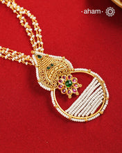 Inspired by the intricate designs of South temple art, this neckpiece is expertly crafted from 92.5% pure silver and finished with a refined dull gold polish. Complemented by a delicate pearl chain, it embodies a harmonious blend of traditional craftsmanship and timeless elegance, ideal for enhancing any special occasion ensemble.