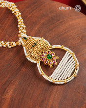 Inspired by the intricate designs of South temple art, this neckpiece is expertly crafted from 92.5% pure silver and finished with a refined dull gold polish. Complemented by a delicate pearl chain, it embodies a harmonious blend of traditional craftsmanship and timeless elegance, ideal for enhancing any special occasion ensemble.