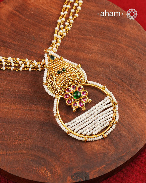 Inspired by the intricate designs of South temple art, this neckpiece is expertly crafted from 92.5% pure silver and finished with a refined dull gold polish. Complemented by a delicate pearl chain, it embodies a harmonious blend of traditional craftsmanship and timeless elegance, ideal for enhancing any special occasion ensemble.