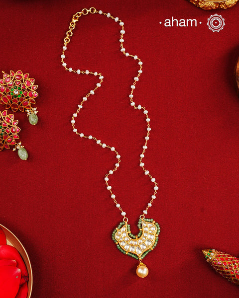 This stunning neckpiece features a delicate 92.5 silver chain with fresh water pearls and beautifully crafted fine kundan gold polished pendant. Add a touch of elegance to your look with this unique and timeless piece.