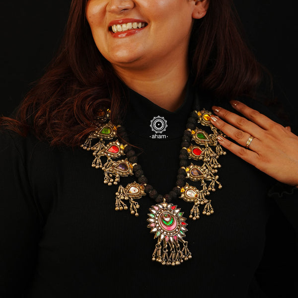 Handcrafted tribal glass silver neckpiece with statement ghungroos. Created by threading together multiple tribal colourful glass pieces giving it a vibrant look. This necklace truly exemplifies the continuity of the traditional prototypes.