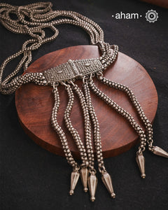 Transform your look with our Vintage Silver Belt Neckpiece. This unique accessory is crafted from a beautiful vintage belt sourced from the south of India and features fine rava work on the main buckle. Elevate any outfit with this versatile and stylish addition to your wardrobe.